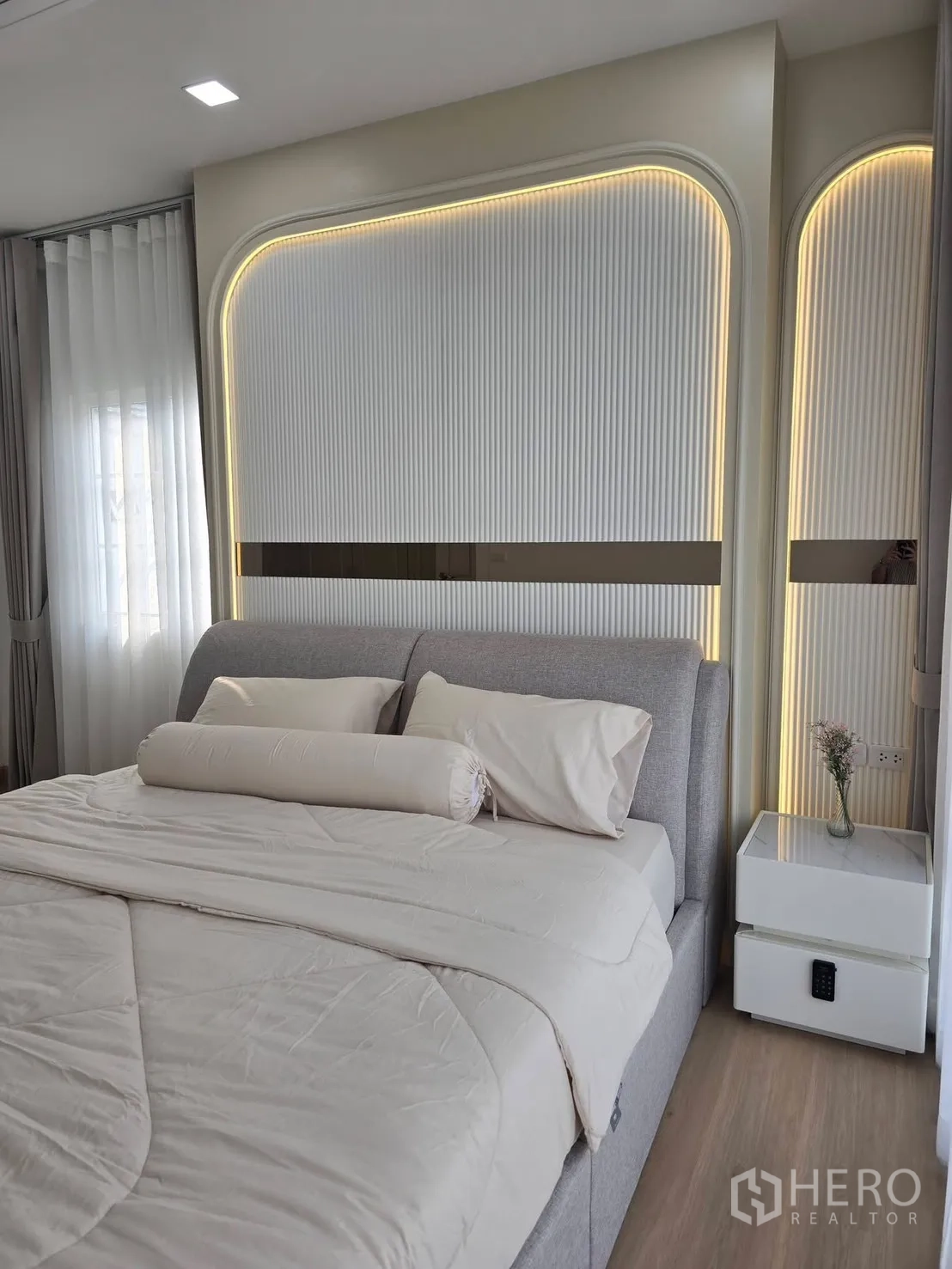 บ้านแฝด for rent in Mueang Samut Prakan, Samut Prakan - ห้องนอนใหญ่เตียงบุนวม พร้อมผนังหัวเตียงไฟ LED และโต๊ะข้างเตียง