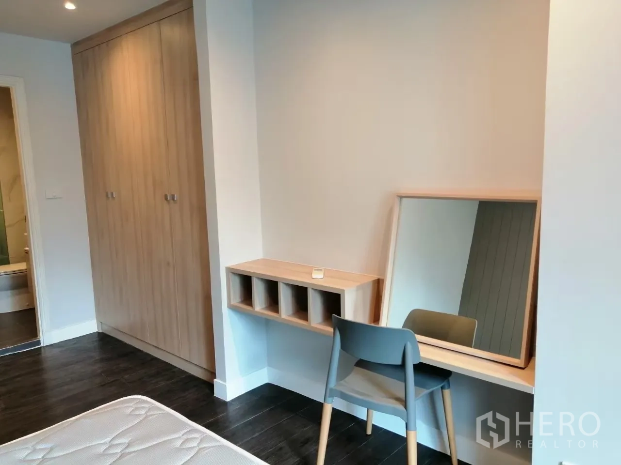 อพาร์ทเมนท์ ให้เช่าในKhlong Toei, Bangkok - มุมห้องนอนมีตู้เสื้อผ้าไม้โทนอ่อนและโต๊ะเครื่องแป้งพร้อมกระจก