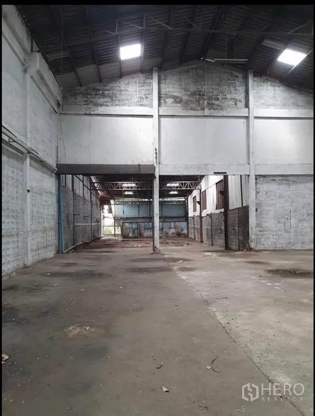 Warehouse for rent in Phra Samut Chedi, Samut Prakan - Deep view across multiple warehouse bays with tall span and concrete flooring.