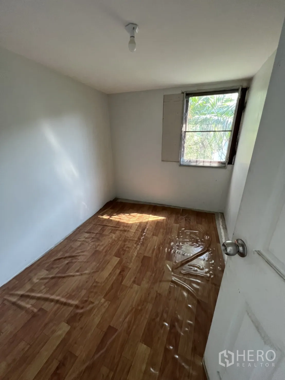 Home Office for rent in Watthana, Bangkok - Dark tiled room with attached bathroom in the corner.