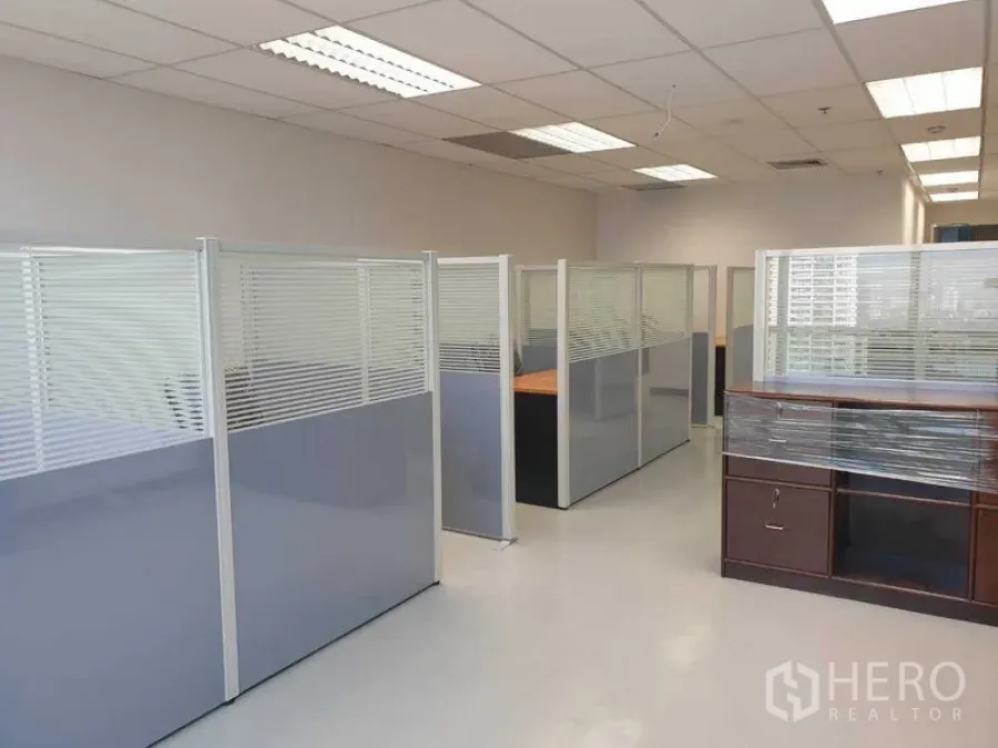 Office Space for rent in Chatuchak, Bangkok - Office corridor of cubicles with window views and a wrapped cabinet.