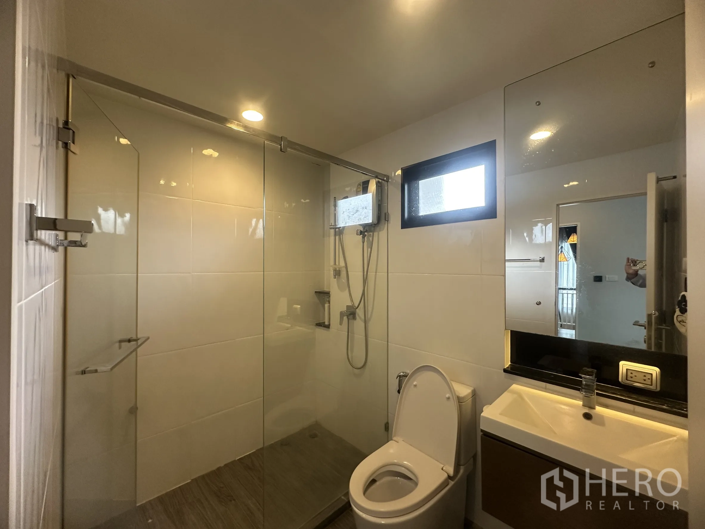 独栋房屋 for rent or sale in Lam Luk Ka, Pathum Thani - 明亮浴室，设玻璃淋浴间、坐便与大镜面。