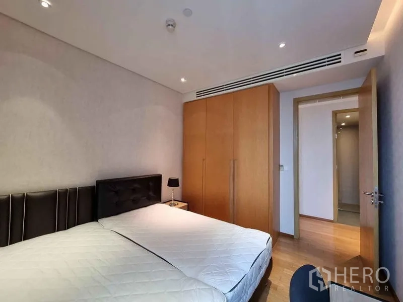 Condominium for rent in Watthana, Bangkok - Cozy second bedroom with built-in wardrobe and warm lighting.