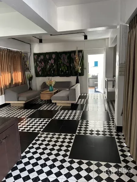 带办公室的家 出租或出售在Phra Khanong, Bangkok - 起居区，黑白棋盘地砖，灰色沙发和长窗帘。