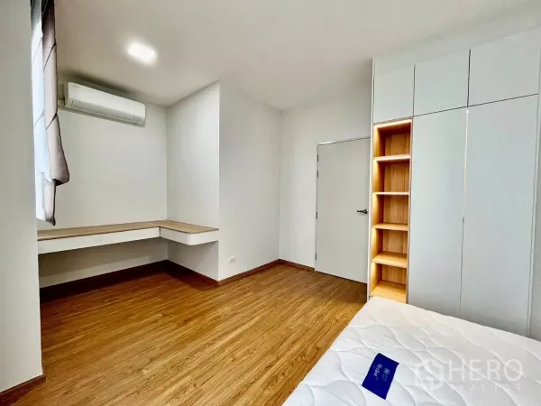 Townhouse for rent in Bang Phli, Samut Prakan - Spacious bedroom featuring an L-shaped study desk, wood floors, and fitted storage.
