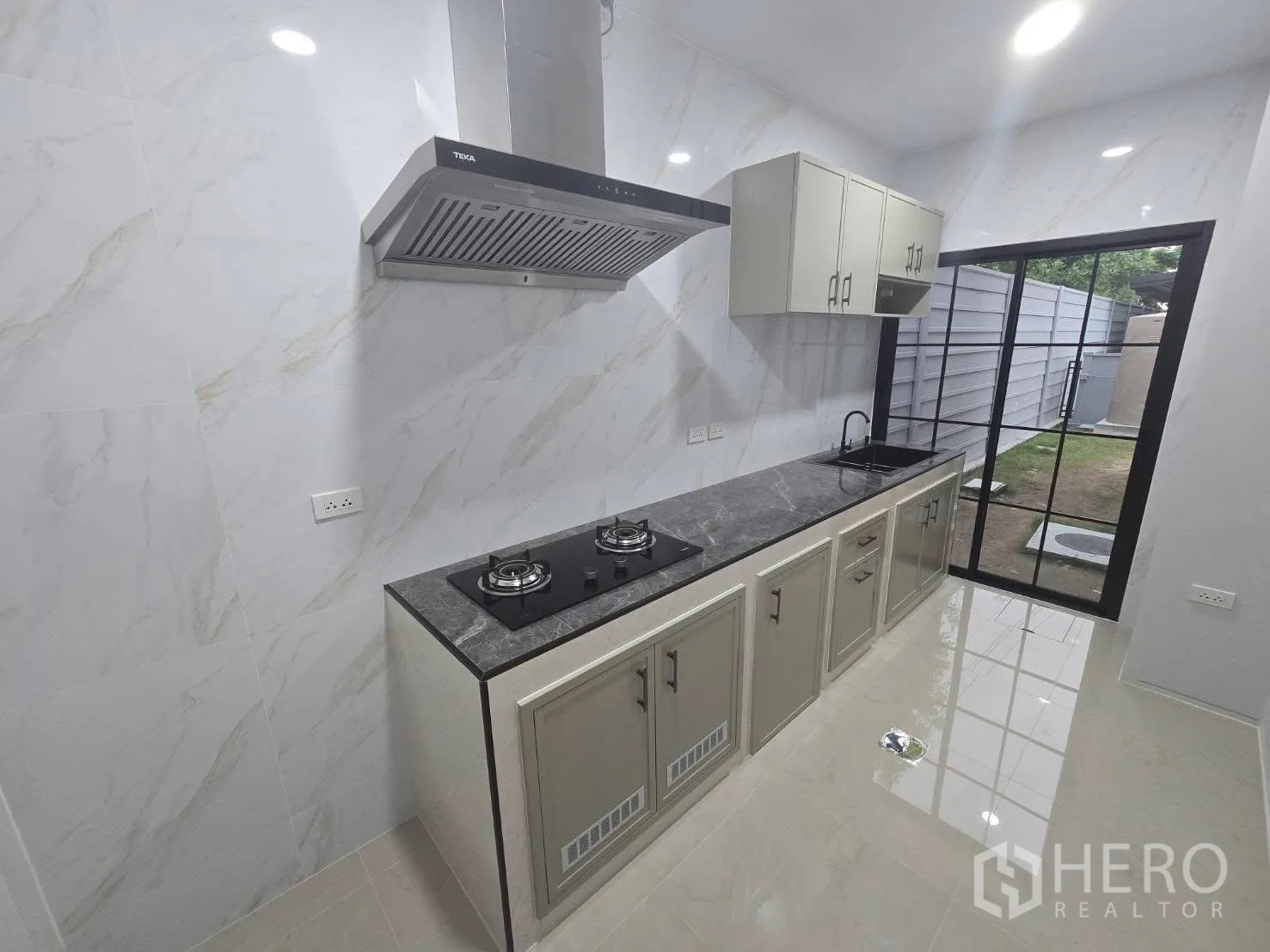 Semi-detached House for rent in Bang Phli, Samut Prakan - Long galley kitchen opening to a sliding glass door and small yard.