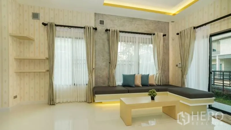 บ้าน ให้เช่าหรือขายในLat Krabang, Bangkok - มุมนั่งเล่นเข้ามุม พร้อมเบาะบิวท์อิน หน้าต่างกระจกบานใหญ่ และไฟ LED ใต้ฐาน