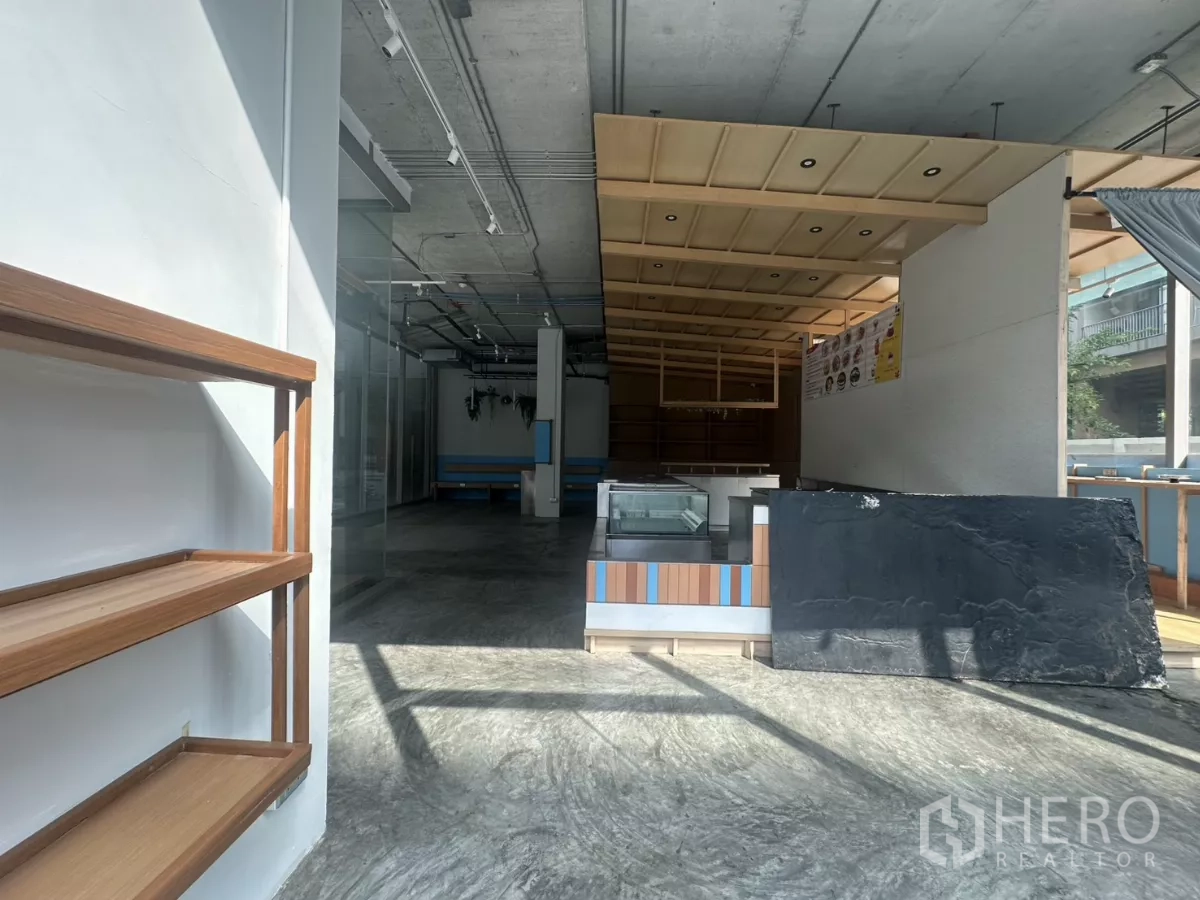 พื้นที่ขายปลีก ให้เช่า - โถงทางเข้าแสงสว่าง มีชั้นวางผนัง พื้นคอนกรีตขัดมัน และไอส์แลนด์เคาน์เตอร์
