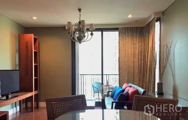 Condominium for rent in Khlong Toei, Bangkok - Another view of the living room with chandelier, seating and balcony access.
