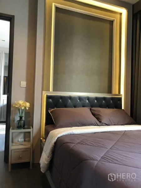 คอนโด ให้เช่าในWatthana, Bangkok - ห้องนอนหรูหราหัวเตียงบุผ้าพร้อมไฟซ่อนโทนอุ่น และโต๊ะข้างเตียงประดับดอกไม้