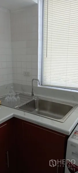 公寓 出租在Watthana, Bangkok - 厨房转角不锈钢水槽，窗帘百叶遮光。