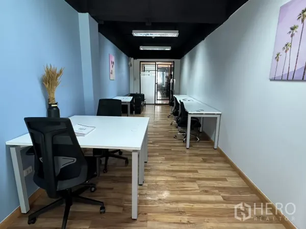 สำนักงาน ให้เช่าในWatthana, Bangkok - ออฟฟิศขนาด 37 ตร.ม. เฟอร์นิเจอร์ครบ โต๊ะทำงาน เก้าอี้สีดำ ผนังสีฟ้า พื้นไม้ และทางเชื่อมไปยังห้องประชุมกระจก