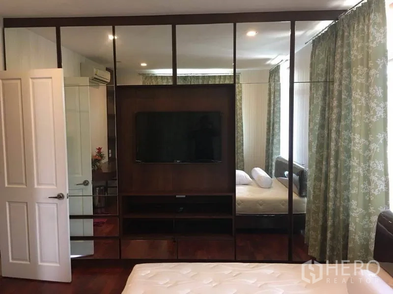 Detached House for rent in Bang Phli, Samut Prakan - Bedroom wall of mirrored wardrobes with an integrated TV and storage shelves.