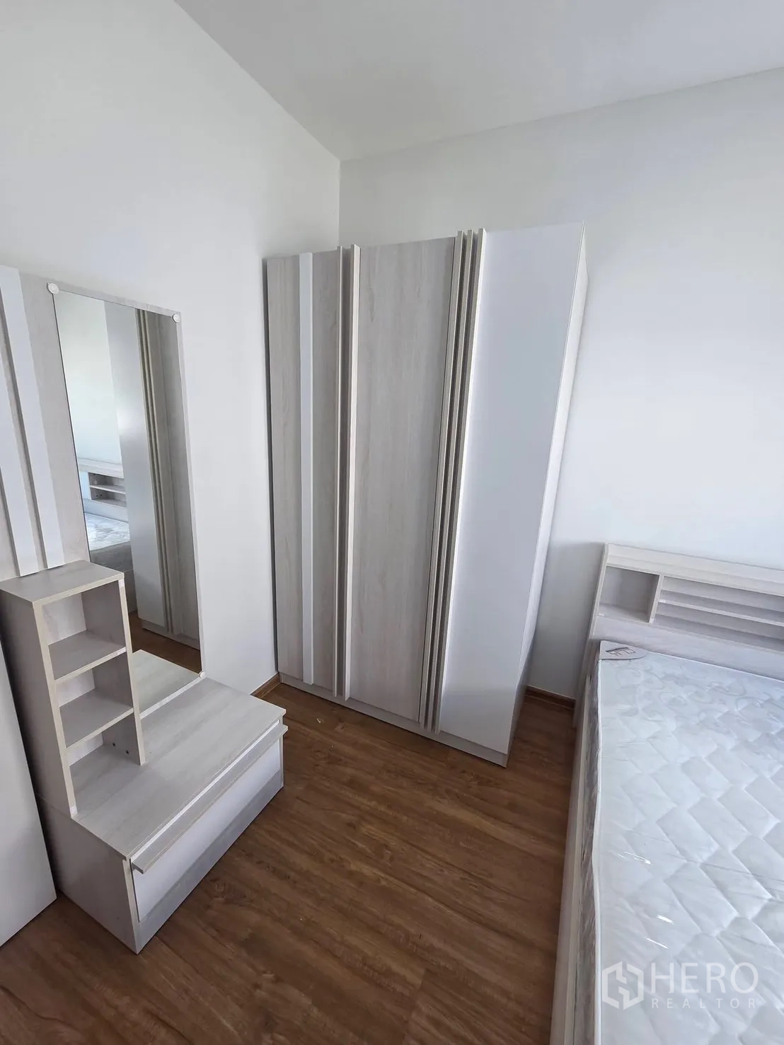 Townhouse for rent in Bang Phli, Samut Prakan - Bedroom furniture set with wardrobe, dressing table, and wood-look flooring.