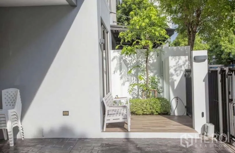 独立式住宅 出租或出售在Lat Phrao, Bangkok - 入户小庭院，长椅与绿植，配私家围栏。