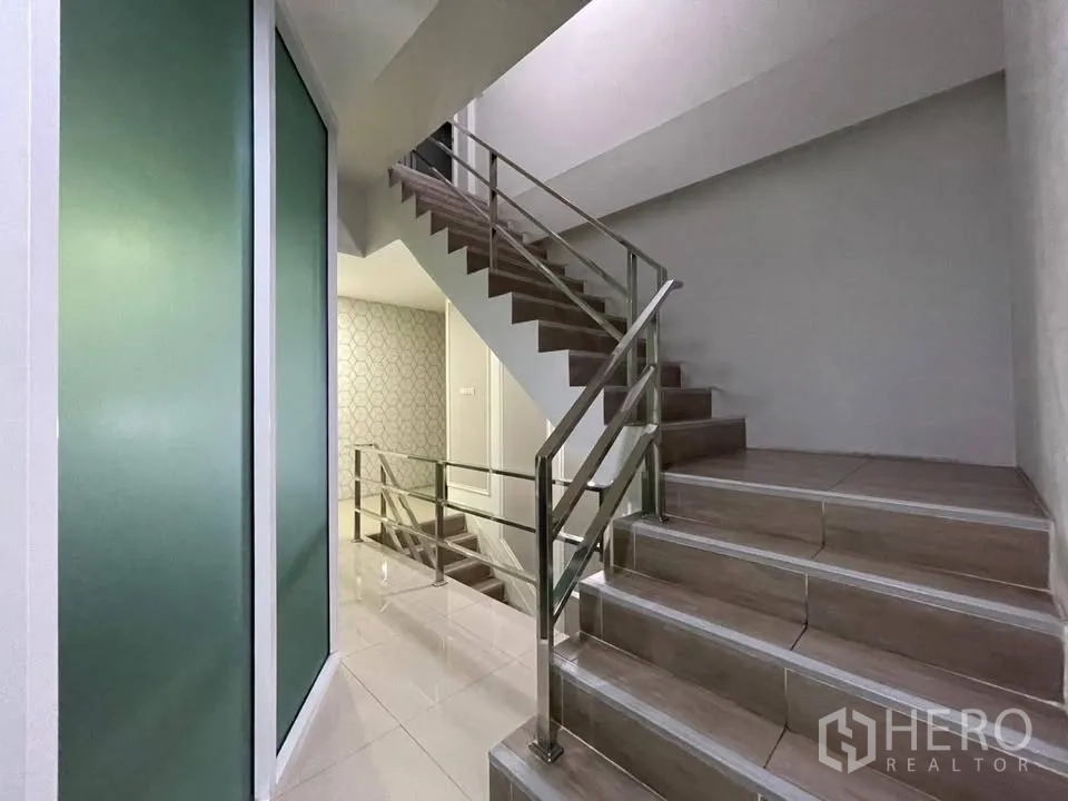 店屋 for sale in Prawet, Bangkok - 室内楼梯，瓷砖踏步与不锈钢扶手，旁有磨砂玻璃。