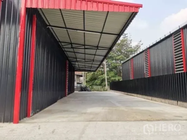 คลังสินค้า ให้เช่าในWang Thonglang, Bangkok - มุมมองด้านหน้าพื้นที่โหลดสินค้ามีหลังคา ระหว่างผนังโลหะสองฝั่ง เหมาะสำหรับรถบรรทุกเข้า‑ออก