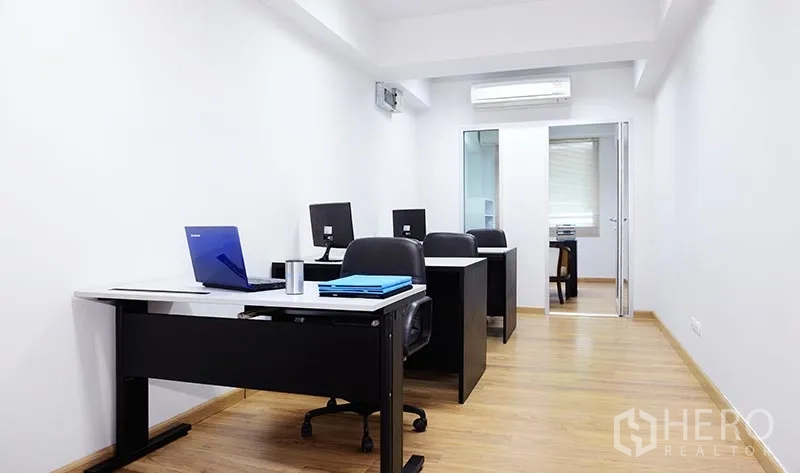 Office Space for rent in Khlong Toei, Bangkok - Private office with three desks, light wood flooring, glass partition and air conditioning.