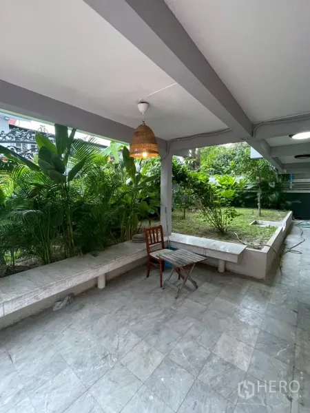 独立式住宅 出租在Watthana, Bangkok - 一层露台铺石地面，内置长凳与抬高花坛。