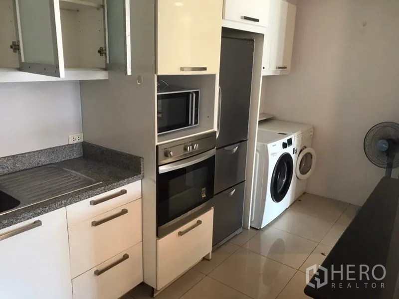 คอนโด ให้เช่าในWatthana, Bangkok - ครัวปิดพร้อมท็อปหิน เตาอบ ไมโครเวฟ ตู้เย็น และเครื่องซักผ้า