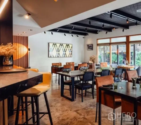 零售空间 出租在Yan Nawa, Bangkok - 温馨餐厅内景，设吧台座位、轨道灯和大窗户。