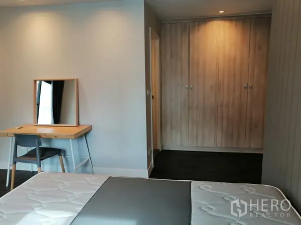 อพาร์ทเมนท์ ให้เช่าในKhlong Toei, Bangkok - ห้องนอนพร้อมโต๊ะทำงาน กระจกบานใหญ่ และตู้เสื้อผ้าเต็มผนังใกล้ประตูห้องน้ำในตัว