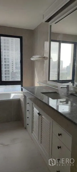 อพาร์ทเมนท์ ให้เช่าในPathum Wan, Bangkok - ห้องน้ำสว่าง เคาน์เตอร์หินแกรนิต ตู้เก็บของ และอ่างอาบน้ำติดหน้าต่างเห็นวิวเมือง