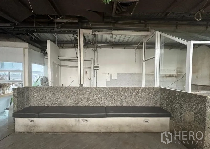 零售空间 出租在Bang Rak, Bangkok - 花岗岩长椅及带玻璃围挡的服务台近景，可见管线。