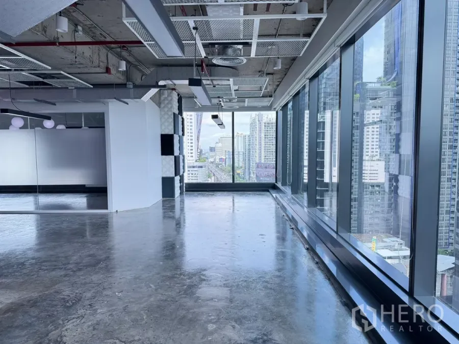 办公空间 出租在Din Daeng, Bangkok - 开放式办公室，落地窗与抛光水泥地面，眺望曼谷天际线。