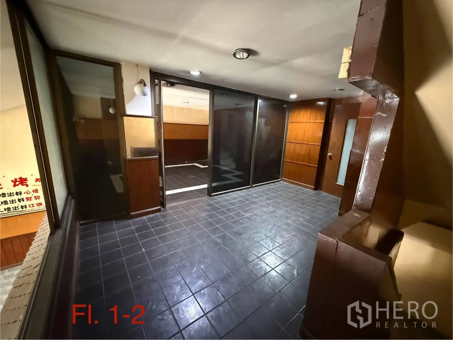 Shophouse for rent in Bang Na, Bangkok - Mezzanine level with glass partitions and dark floor tiles overlooking the front hall.