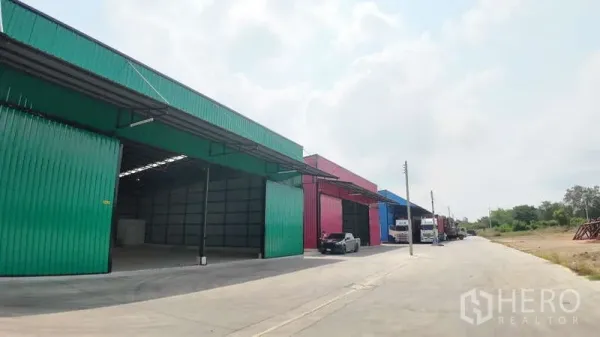 Warehouse for rent in Mueang Chachoengsao, Chachoengsao - Perspective of colorful warehouse units featuring canopies, loading areas, and ample truck turning space.