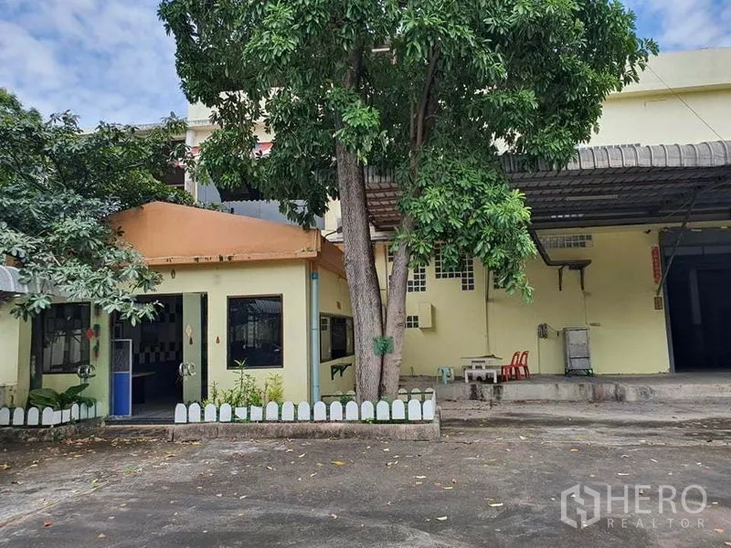 工厂 出售在Bang Khun Thian, Bangkok - 厂区外立面，含办公楼、雨棚与院内大树