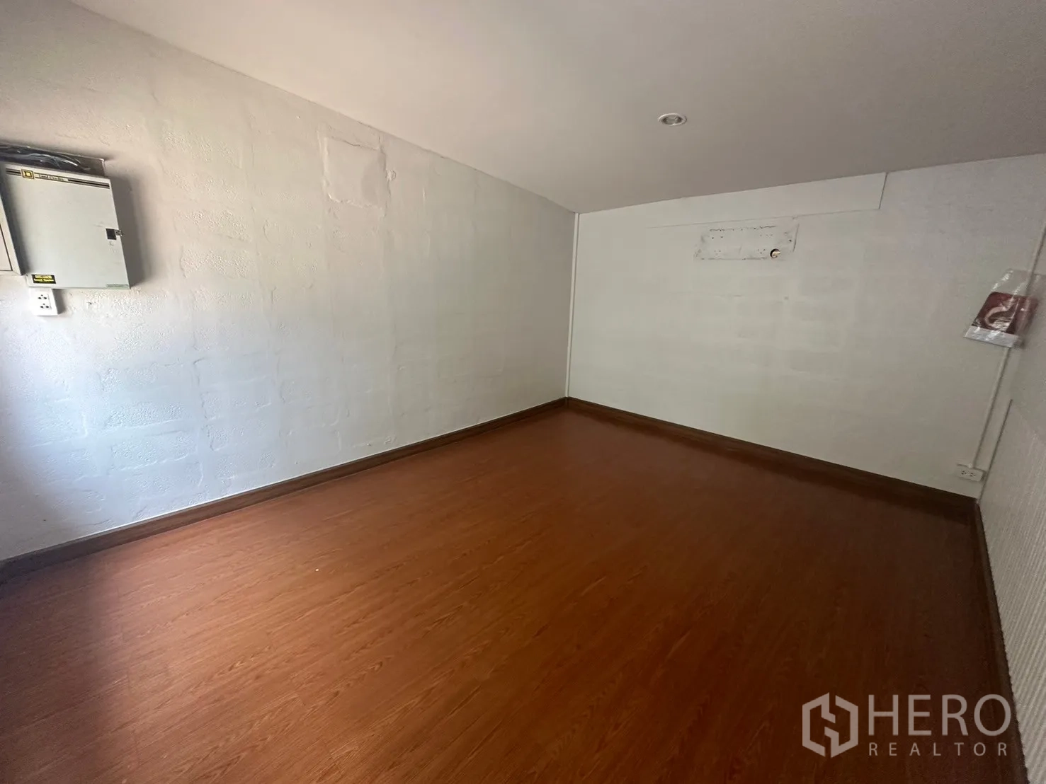 Warehouse for rent in Din Daeng, Bangkok - Compact office with wood flooring and an electrical panel.