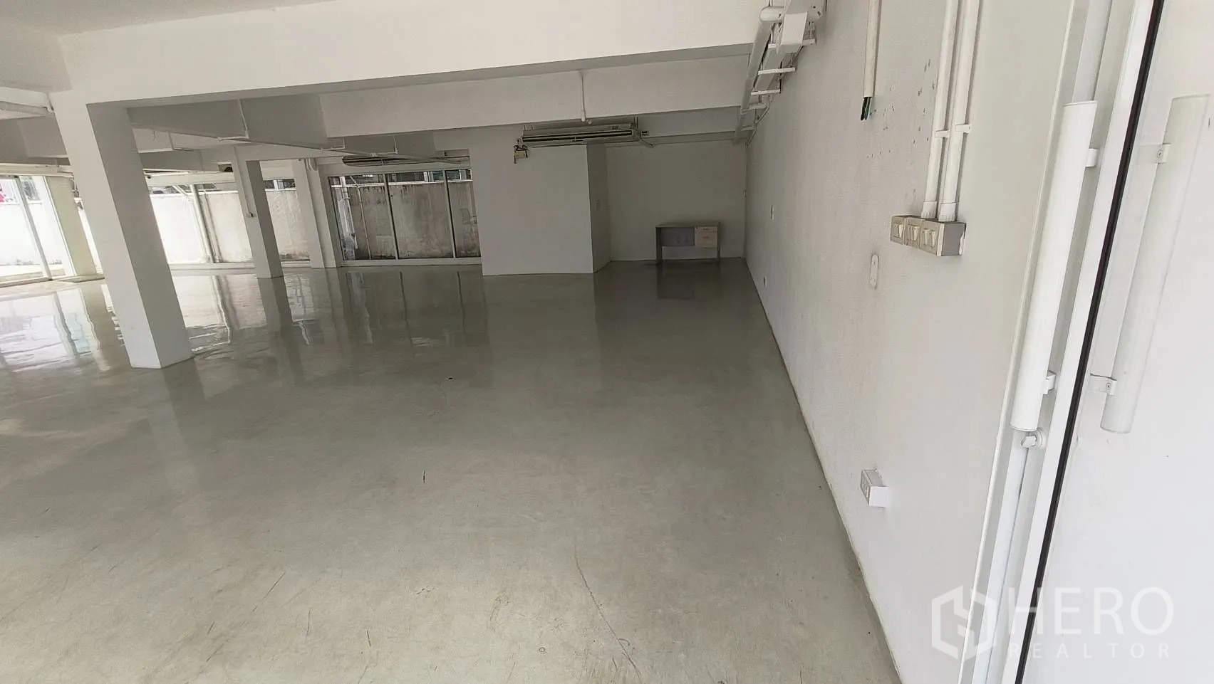 Office Space for rent in Khlong Toei, Bangkok - Large empty workspace with reflective floor and glass partitions.
