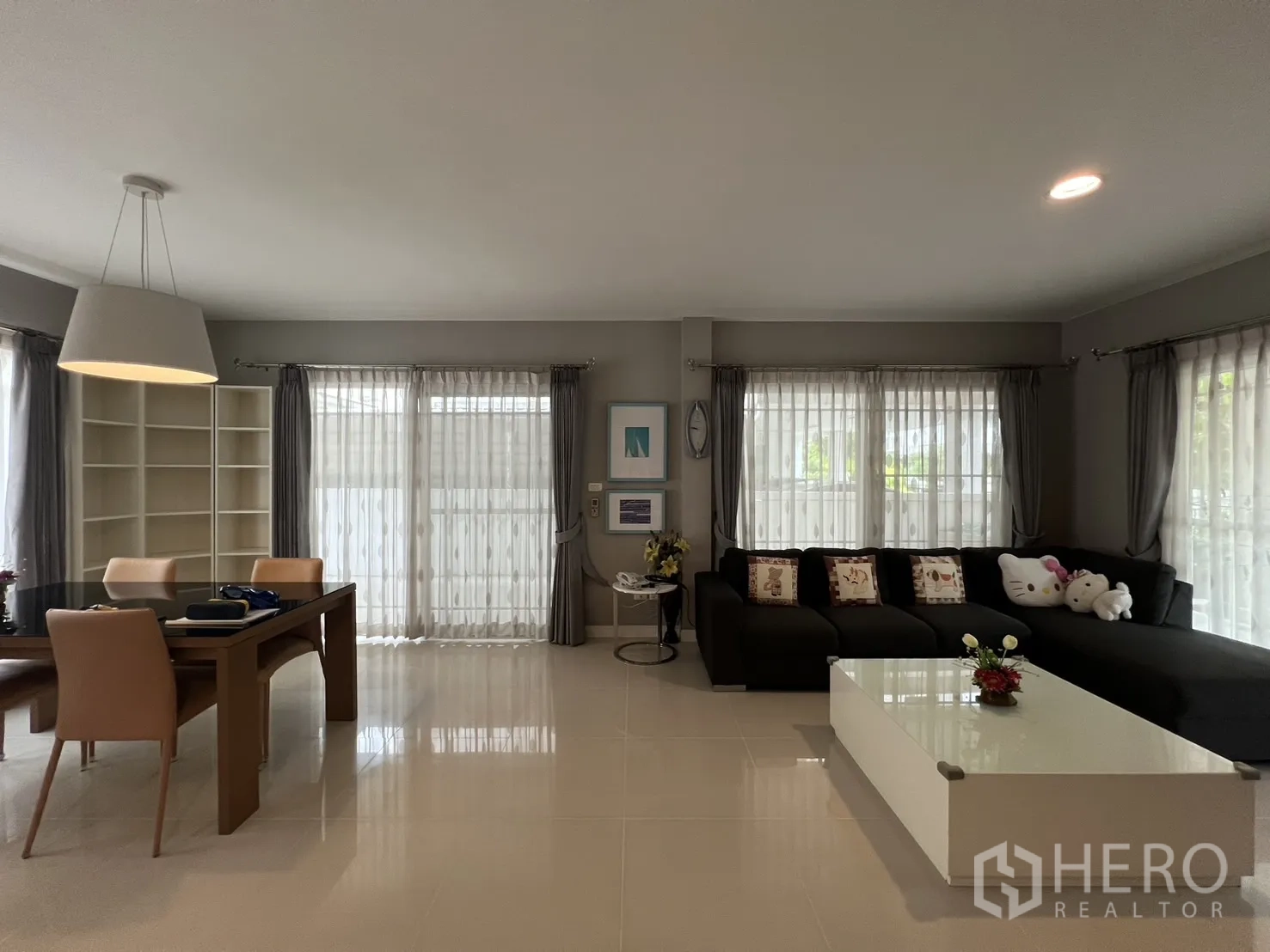 Detached House for rent in Bang Kapi, Bangkok - Open-plan living and dining area with large windows and sheer curtains.