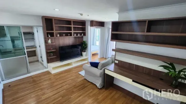 公寓 出售在Yan Nawa, Bangkok - 客厅设有木质壁柜、电视墙和内置书桌。