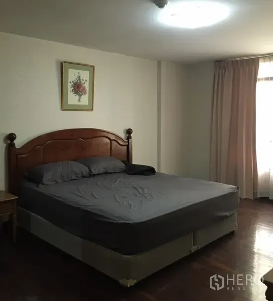 คอนโด ให้เช่าในWatthana, Bangkok - ห้องนอนใหญ่กว้าง เตียงขนาดใหญ่ หัวเตียงไม้ และหน้าต่างพร้อมผ้าม่านรับแสงธรรมชาติ