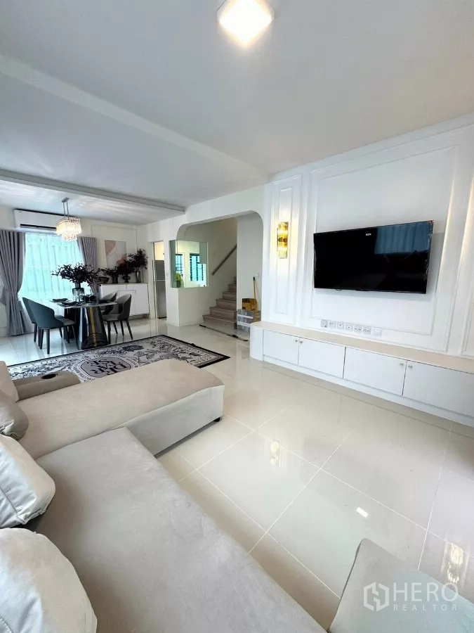 Detached House for rent in Bang Phli, Samut Prakan - Spacious lounge with glossy tile floors, media wall and access to stairs.