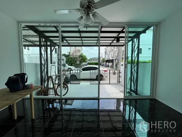 ทาวน์เฮาส์ ขายในBang Kapi, Bangkok - ห้องหน้าบ้านกั้นกระจกบานเลื่อน เปิดออกสู่ที่จอดรถมีหลังคา