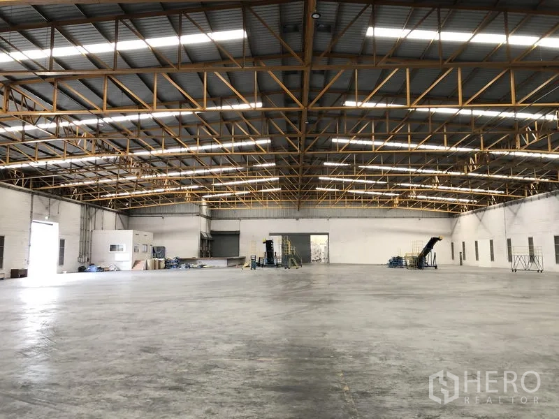 Warehouse for rent in Phra Nakhon Si Ayutthaya - Open industrial hall with polished concrete floor and multiple loading bay doors.