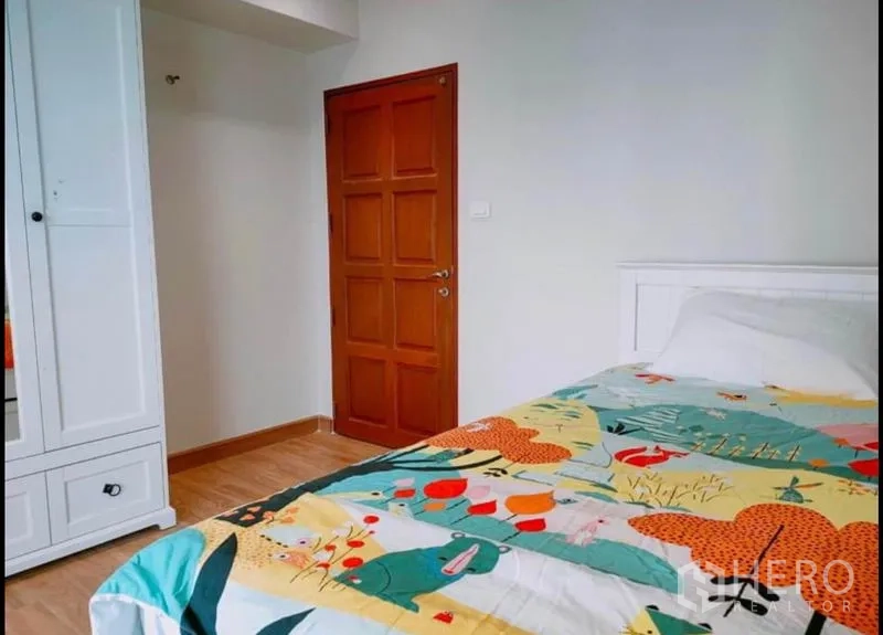 คอนโด ขายในWatthana, Bangkok - ห้องนอนรับแขกอบอุ่น ตู้เสื้อผ้า ประตูไม้ และผ้าปูที่นอนลายสีสัน