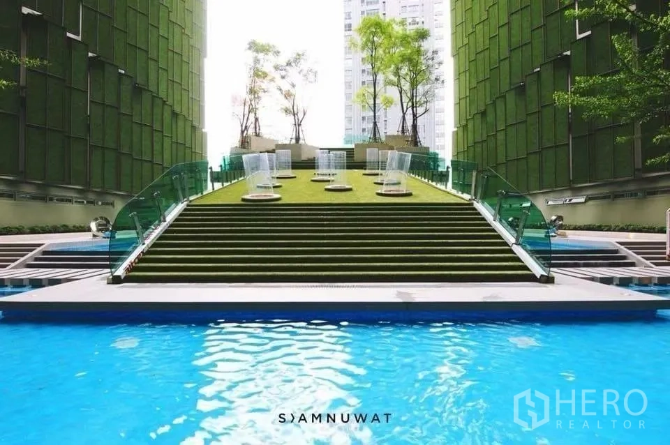 คอนโด for rent in Ratchathewi, Bangkok - สระว่ายน้ำกลางแจ้งพร้อมบันไดสนามหญ้าตรงกลางและอาคารล้อมรอบ