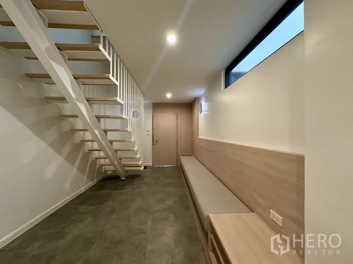 带办公室的家 出租在Phra Khanong, Bangkok - 楼梯厅设悬浮踏步、长条座椅与高窗引入天光。