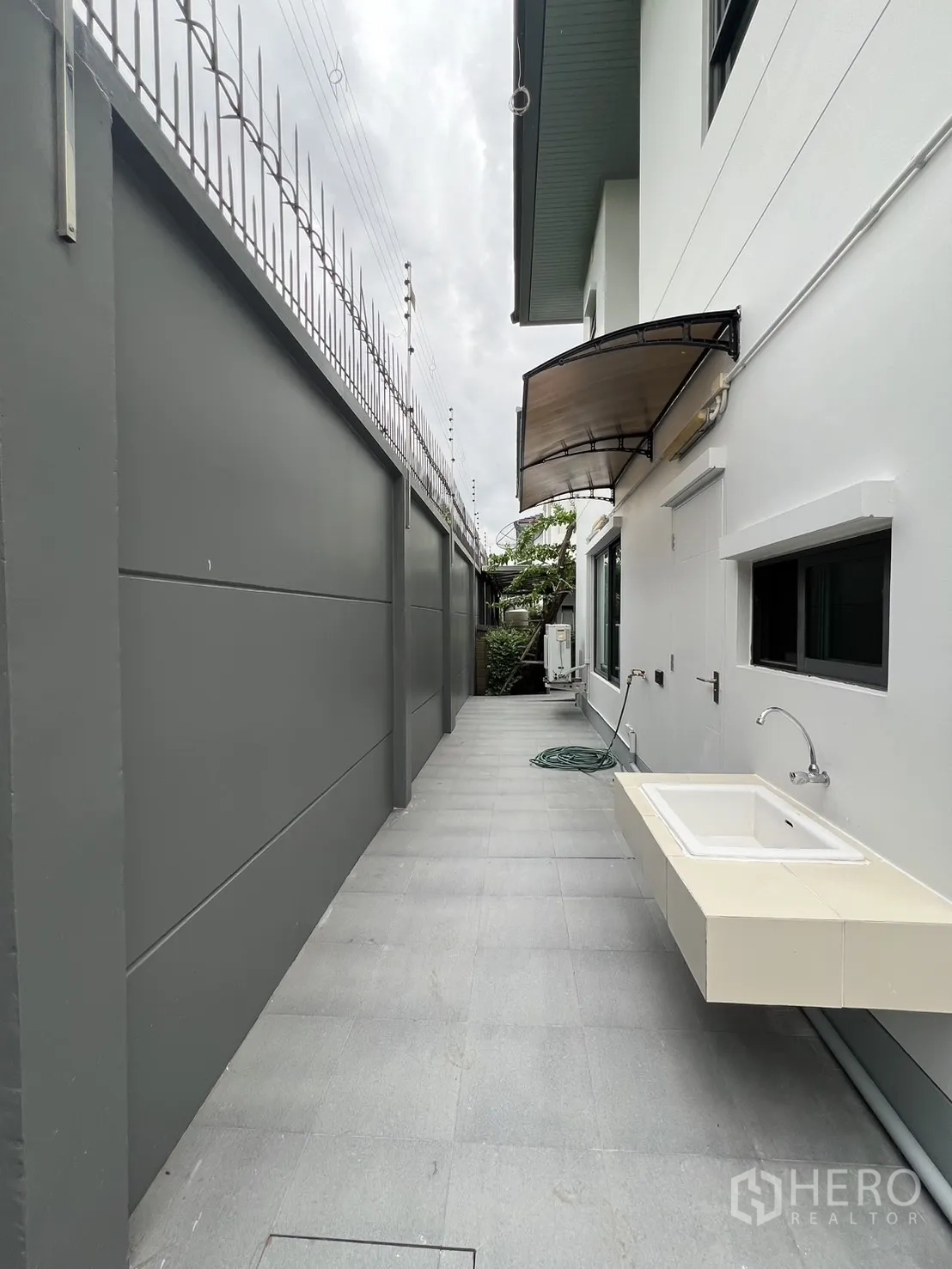 独立式住宅 出租在Bang Kapi, Bangkok - 后方实用区，室外水槽、瓷砖地面与高隐私墙。