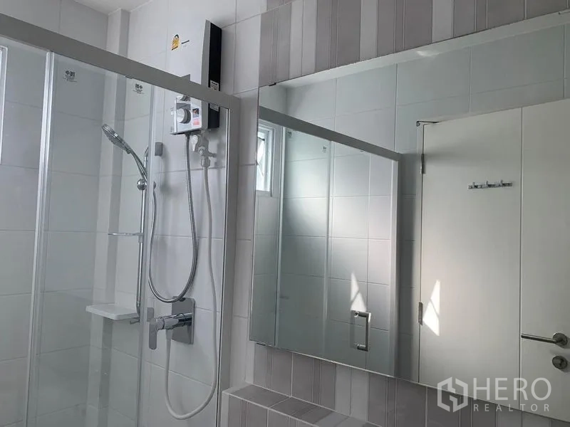 联排别墅 出租 - 明亮浴室，玻璃淋浴间、手持花洒与大镜子。