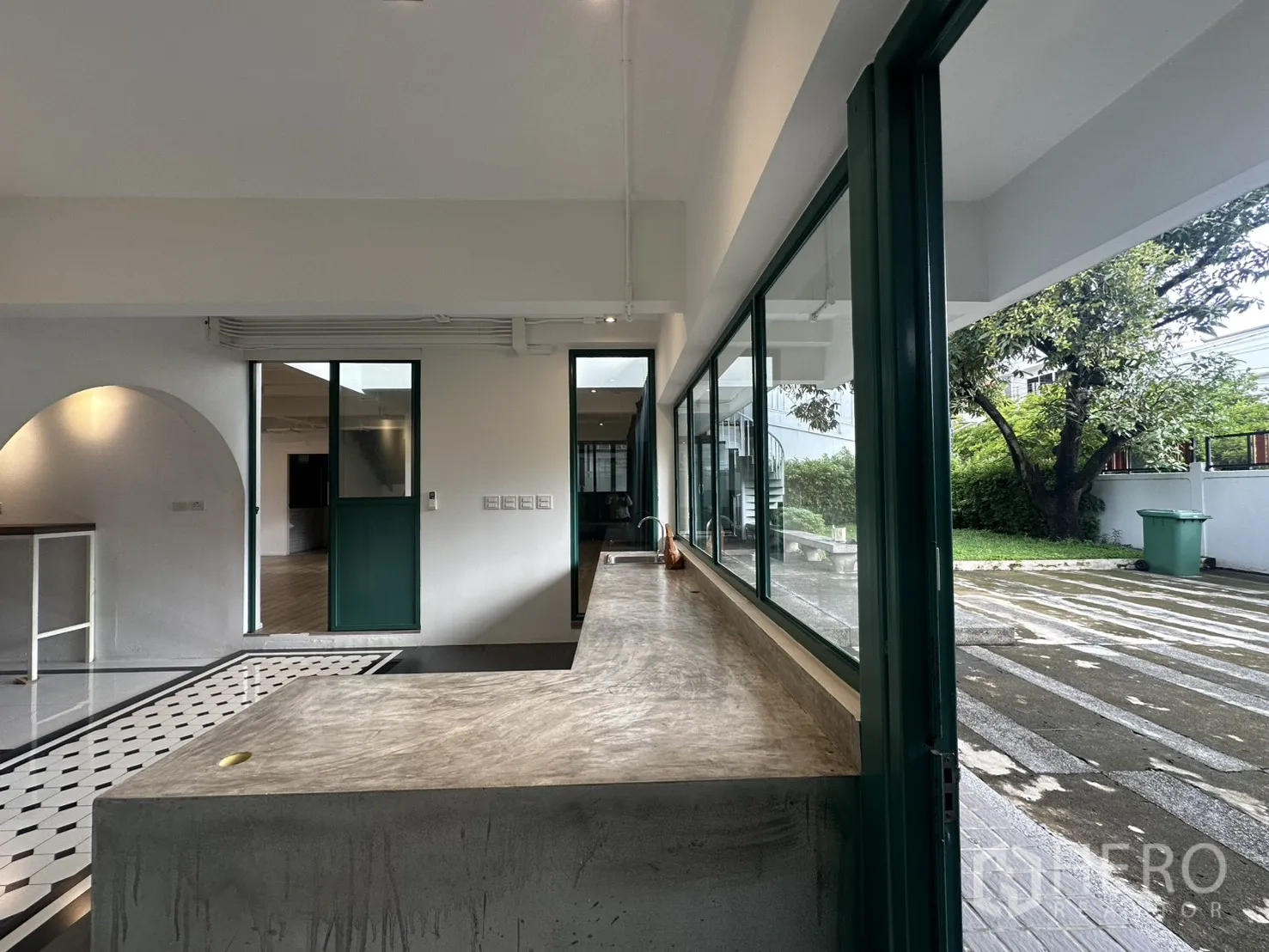 สำนักงานที่บ้าน ให้เช่าหรือขายในPhra Khanong, Bangkok - เคาน์เตอร์แพนทรีคอนกรีตกับประตูกระจกบานเลื่อนเปิดสู่สวนและลานบ้าน