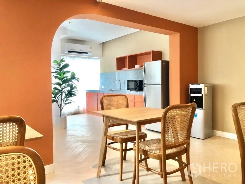 Office Space for rent in Khlong Toei, Bangkok - Bright office pantry with archway, wooden tables and rattan chairs, plus fridge, microwave and water dispenser.
