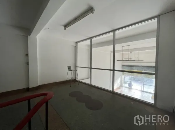 店屋 出租在Phra Khanong, Bangkok - 玻璃围合的夹层办公室，俯瞰前方营业区。