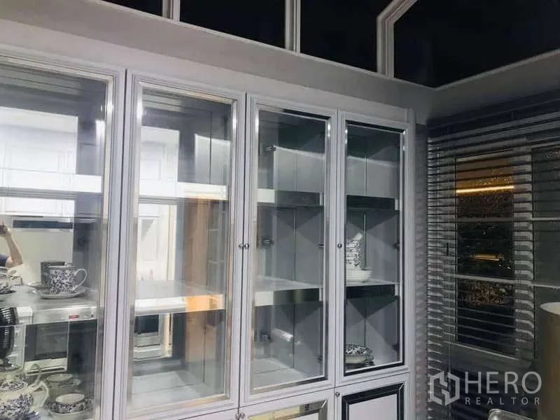 独立式住宅 出租在Chom Thong, Bangkok - 整面玻璃展示柜，柜内照明与百叶窗相映。