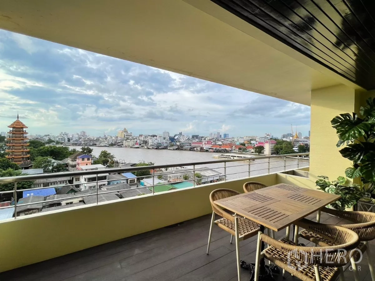 คอนโด ให้เช่าในKhlong San, Bangkok - ระเบียงกว้างพร้อมโต๊ะและเก้าอี้ รับวิวแม่น้ำและเจดีย์แลนด์มาร์ก
